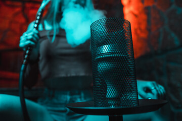 Girl smokes a hookah in blue neon lighting © Evgeny