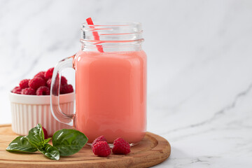 raspberries smoothie in a glass jar on the breakfast with raspberries, copy space