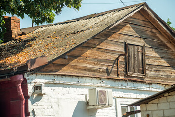 Old wooden gable roof covered with slate against the blue sky