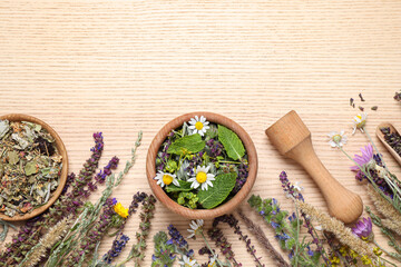 Flat lay composition with healing herbs on wooden table