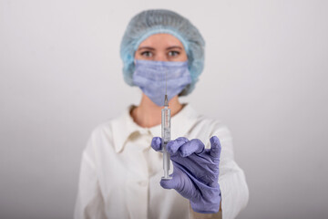 medical worker in blue gloves holds a syringe with a vaccine