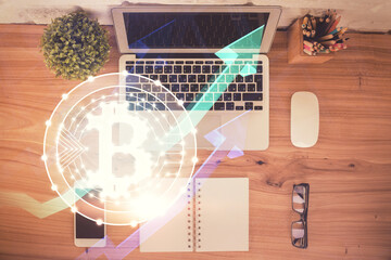 Blockchain theme hologram drawings over computer on the desktop background. Top view. Double...