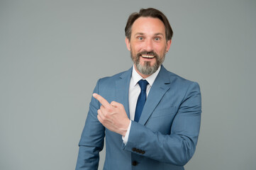 Businessman smiling mature man pointing copy space, promoting services concept