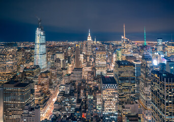 From above of night New York City with illuminated colorful skyscrapers against dark sky