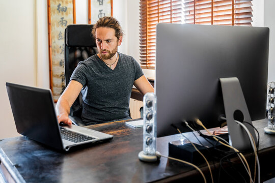 Handsome man working at desktop computer at home