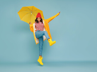 Excited ethnic female leaping with umbrella.