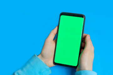 using smart phone with green screen. hands scrolling pages, tapping on touch screen. top view. Chroma key