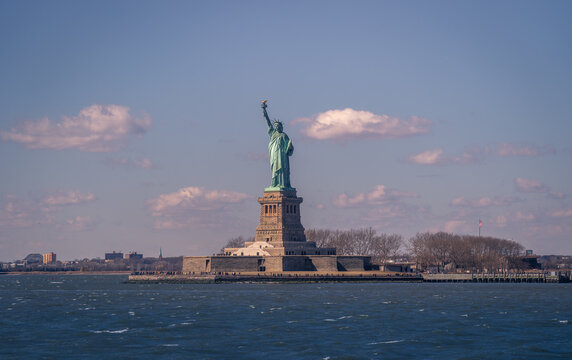 Magnificent view of colossal Statue of Liberty located on Liberty Island in New York against blue cloudy sky in spring day
