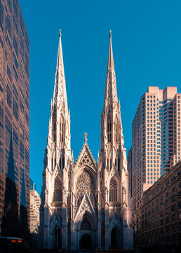 Low angle exterior of famous Neo-Gothic styled Cathedral of St Patrick located on Manhattan in New York City against cloudless blue sky in sunny day