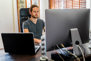 Handsome man working at desktop computer at home