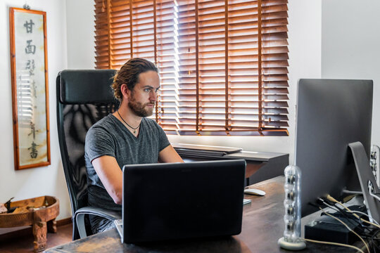 Handsome Man Working At Desktop Computer At Home