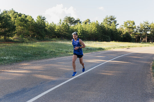 Determined man running on road during workout