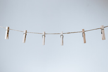 light wooden clothespins on a craft cord on a white background