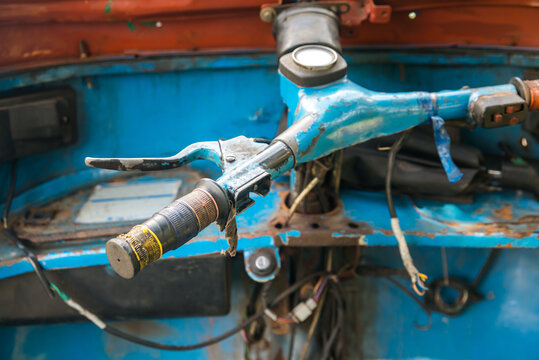 Interior of automotive rickshaw with weathered handle bars made of metal