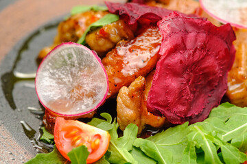 Grilled grilled meat in sauce with vegetables on a white plate.