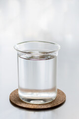 Glass of fresh water, on white desk.