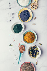 Variety of healthy food supplements such as blue matcha, butterfly pea flowers, collagen powder, spirulina powder, vitamins for vegans and vegetarians, flax and chia seeds,
