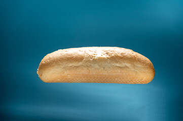 Hot dog bun on a turquoise background. Bun in levitation.