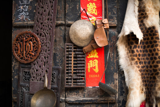 Various shabby symbolic items placed on wooden wall in local souvenir market in Shanxi