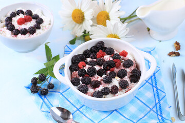 Cottage cheese with raspberries, milk and blackberries, selective focus.Useful natural breakfast with ingredients, baby food Healthy food concept, top view, place for text