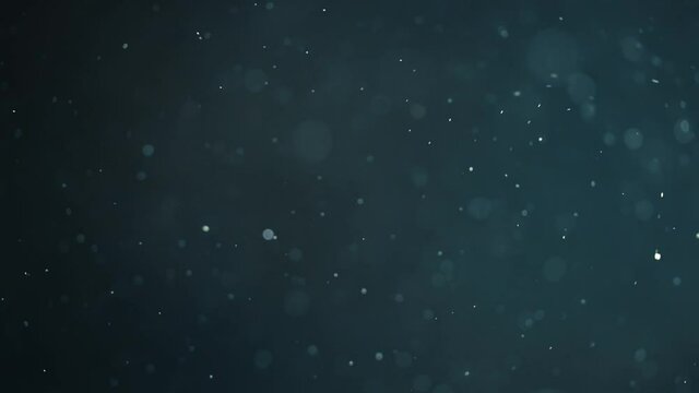 Floating abstract particle bokeh on dark background