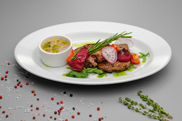 Grilled maso with vegetables and rosemary on a white plate.
