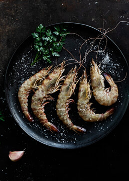Prawns served in plate on table on dark background