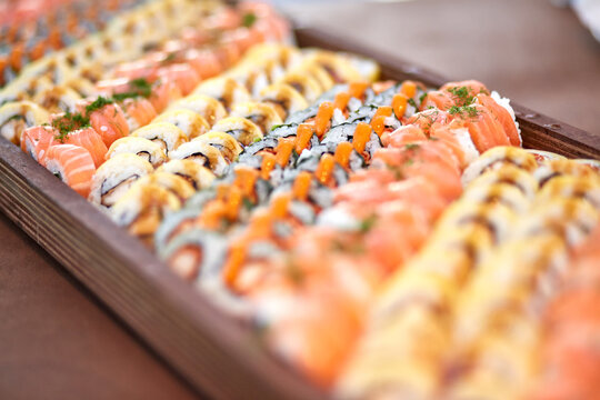 High angle of assorted palatable sushi and rolls placed in plastic containers in store