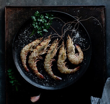 Prawns served in plate on table on dark background