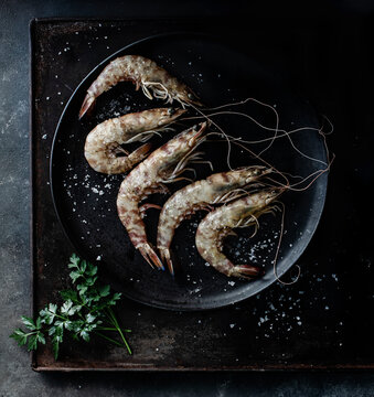 Prawns served in plate on table on dark background