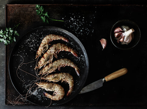 Prawns served in plate on table on dark background