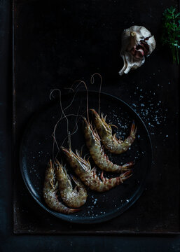 Prawns served in plate on table on dark background