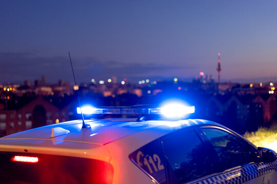 Contemporary police vehicle with siren light on the road on background of amazing night cityscape
