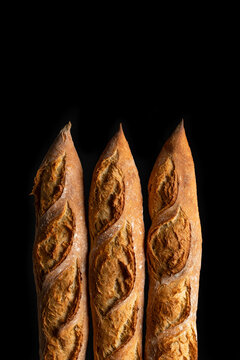 Tasty crunchy baguette in bakery on black background