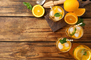 Fototapeta na wymiar Delicious refreshing drink with orange slices on wooden table, flat lay. Space for text