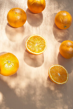 From above of halves of ripe oranges arranged on orange background with shadows