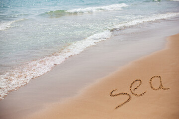 Fototapeta premium Beautiful seascape and beach. The inscription on the sea shore on the sand of the floor of the Sea.