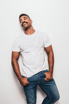 Serious black man with casual outfit posing over white background looking away