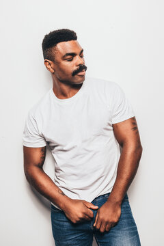 Serious black man with casual outfit posing over white background looking away