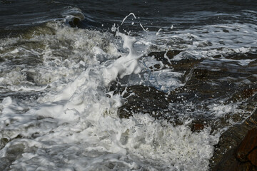 Surf crashed down on the beach. Waves and foam on the dead sea