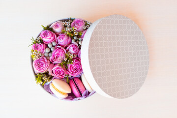 Gift box with pink roses and sweet french dessert macaroons for Valentine's Day gift
