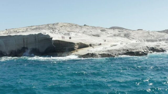 Aerial View of Sarakiniko Beach with Waves crashing into rocks in Milos, Greece