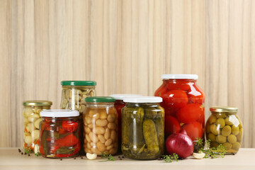 Jars of pickled vegetables on wooden table