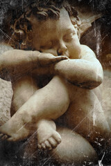 Fototapeta na wymiar Antique statue of little angel with wings. Retro and vintage styled image.