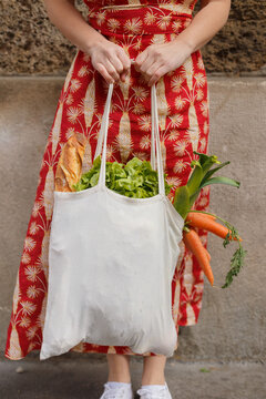 Cropped unrecognizable female standing with reusable shopping bag full of groceries during coronavirus epidemic