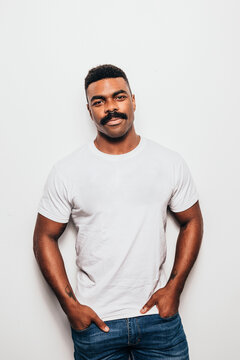 Serious black man with casual outfit posing over white background and looking at camera