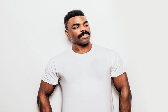 Serious black man with casual outfit posing over white background looking away