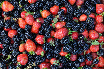 close-up of fresh ripe strawberries and  blackberries after harvesting in the garden, high angle...