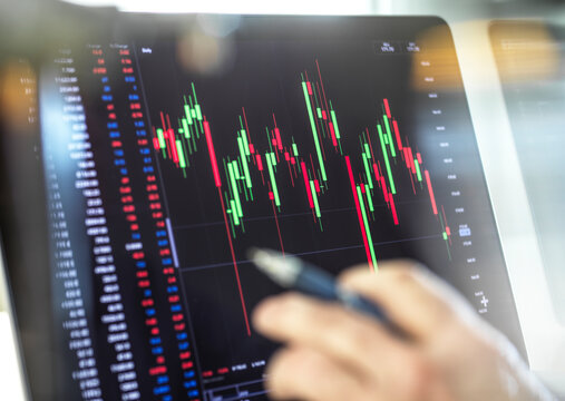 Close-up of broker hand and computer monitor with graph