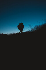 Silhouette of backpacker hiking under the moonlight